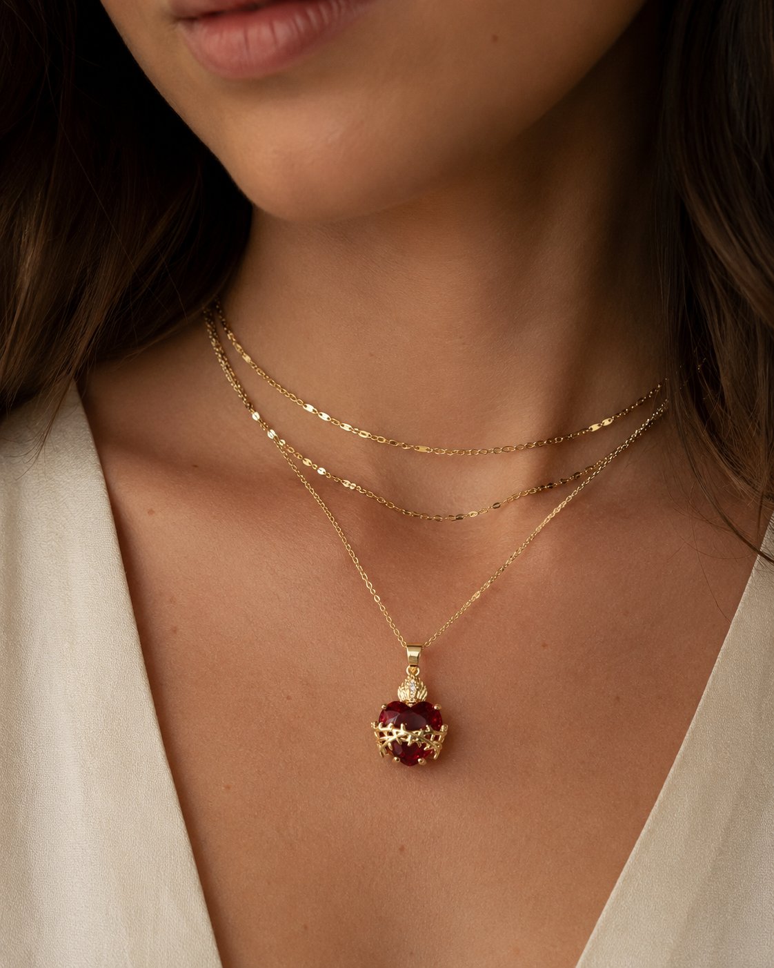 Modelo usando colar dourado com pingente de coração vermelho